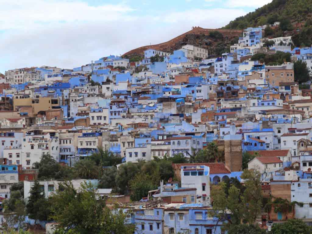 View of the medina of Chefchaouen, lots of blue houses on a mountain side.