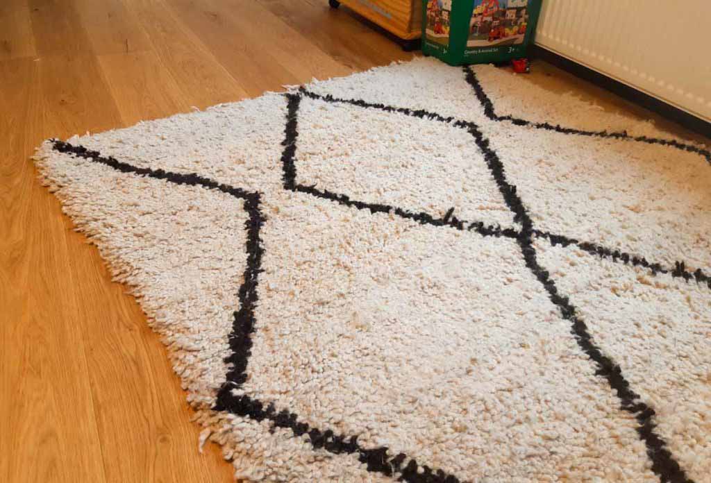 white carpet with black pattern on wood floor