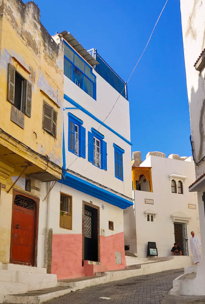 Houses painted yellow, blue, pink and white in the medina of Tangier, Morocco. One of the best things to do in Tangier is getting lost walking around the medina