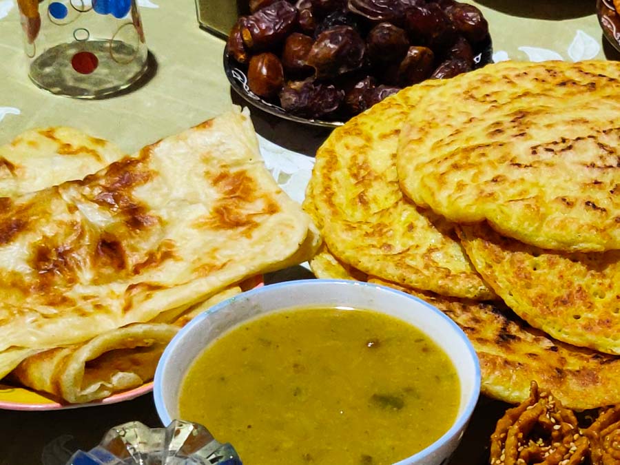 Ein Tisch voll Essen, verschiedene Fladenbrote, Suppe und Datteln. Iftar, das Fastenbrechen im Ramadan in Marokko