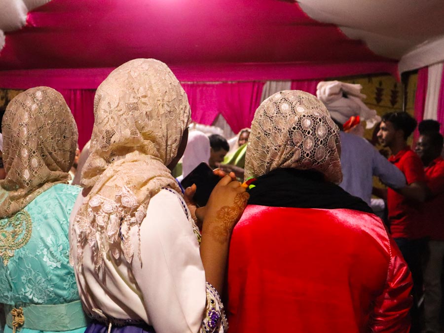 back view of 3 women in traditional dresses and head scarfs