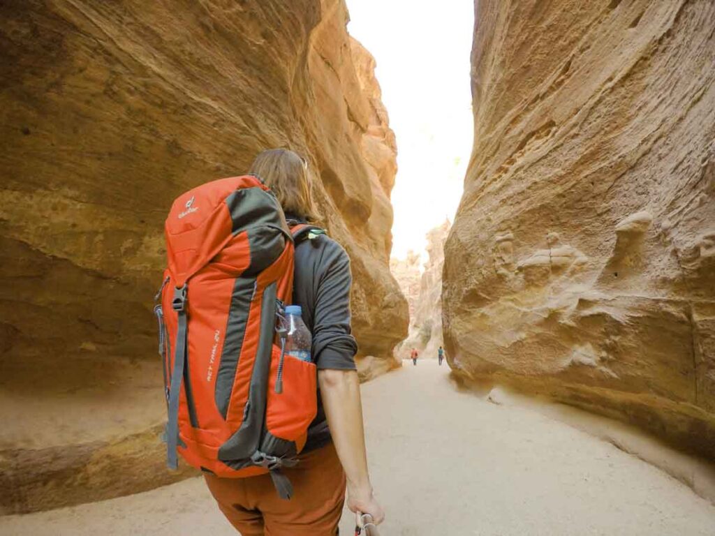 Frau von hinten, roter Tagesrucksack auf dem Rücken, im Siq von Petra mit steilen Felsen auf beiden Seiten
Reiseausrüstung
Deuter Tagesrucksack ACT Trail 24