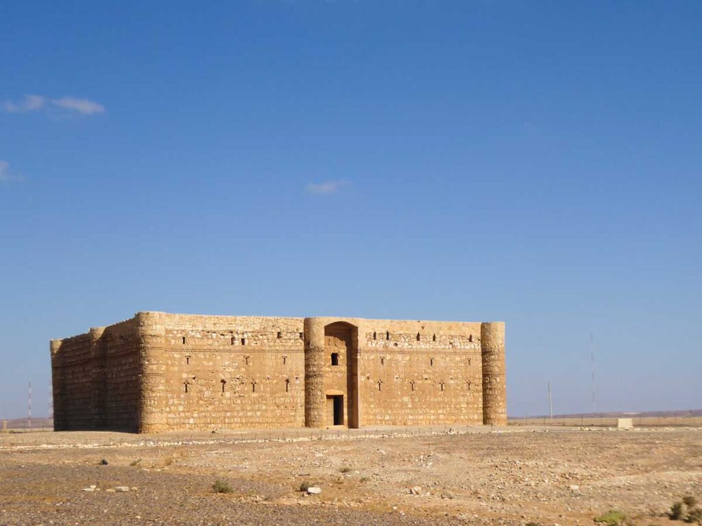 Desert castles Jordan, Qasr Kharaneh, a big brick building with small windows in the middle of a rocky desert