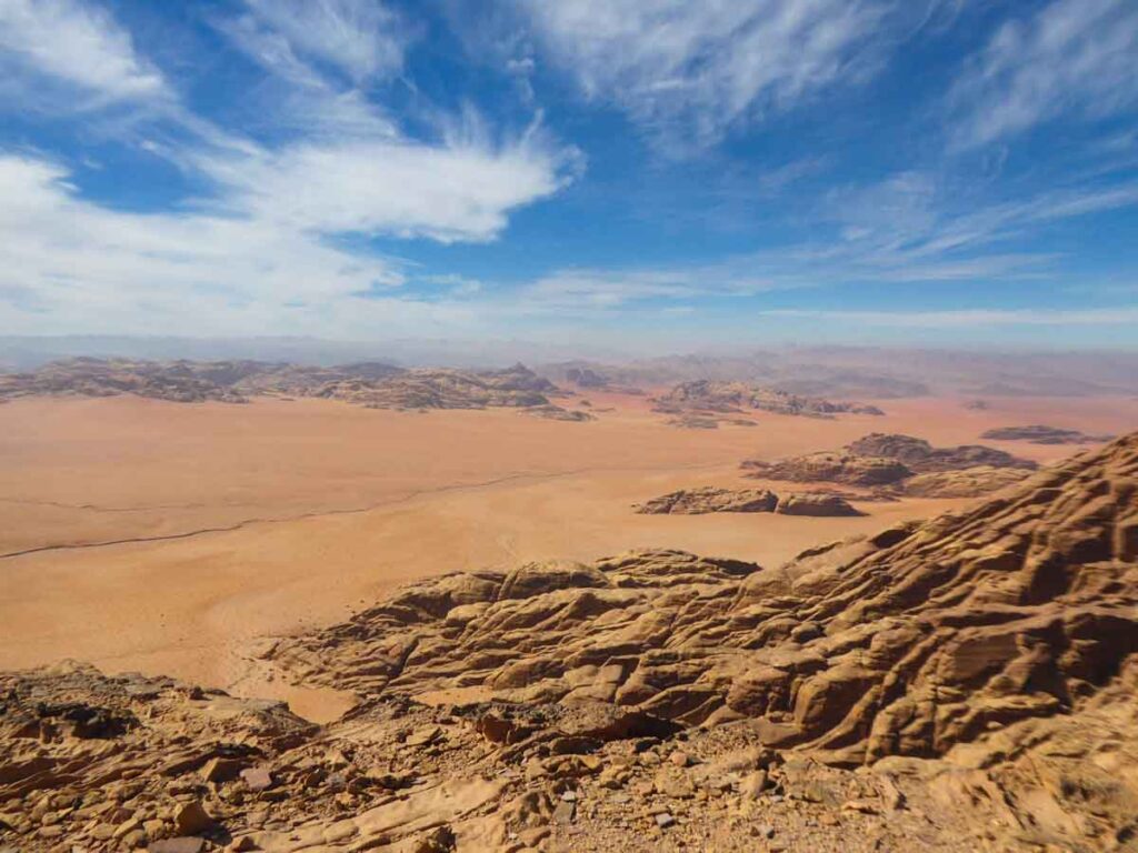Wadi Rum Jordanien, langes, weites Tal mit orange-rotem Sand und auf beiden Seiten Felsen