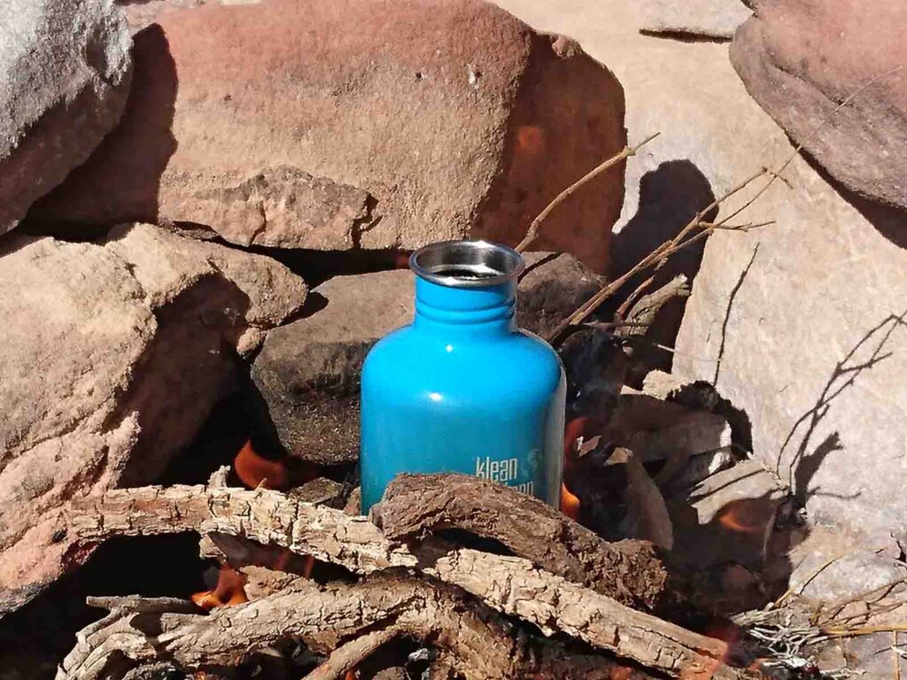 hellblaube Metallflasche steht zwischen Steinen und Holz im Feuer
Reiseausrüstung
Kleankanteen Flasche blau