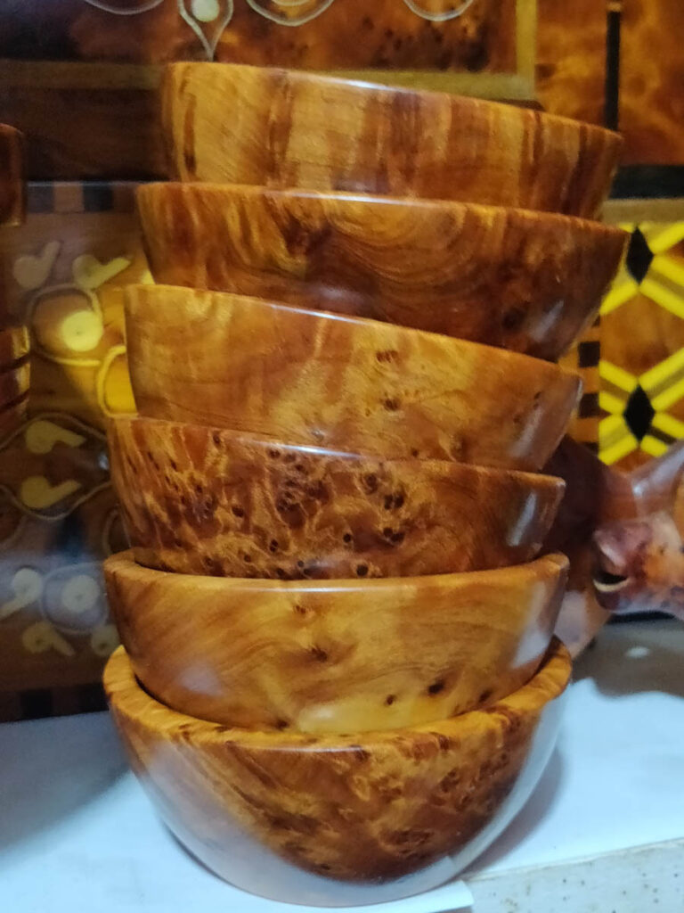 stack of reddish brown bowls made from thuya wood, souvenirs in essaouira