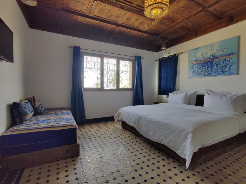 double bed in a blue decorated room in the Desert Villa in Merzouga, one of the best hotels in Merzouga